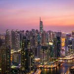Sunset view of Dubai Marina skyline with modern skyscrapers and waterfront.