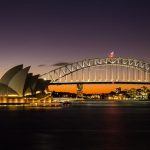 A panoramic view of Sydney Harbour featuring the Opera House and Harbour Bridge.