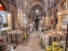 Interior view of Tabriz Grand Bazaar with people walking through arched corridors