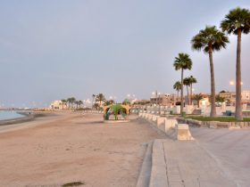 Beautiful coastal view of Al Khor, Qatar, with clear skies, calm waters, and boats near the shore, perfect for a travel blog header.