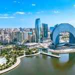 Aerial view of Baku's modern skyline along the Caspian Sea at sunset.