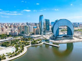 Aerial view of Baku's modern skyline along the Caspian Sea at sunset.