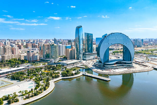 Aerial view of Baku's modern skyline along the Caspian Sea at sunset.