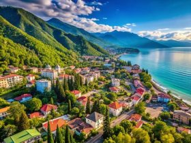 Seaside view of Gagra with palm trees, Black Sea coastline, and Caucasus Mountains in the background