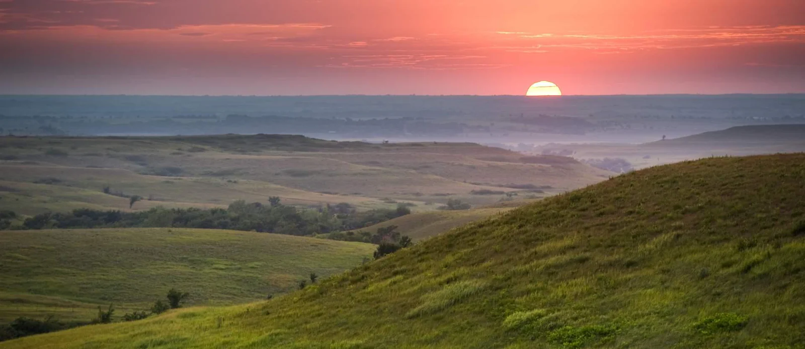 Kansas scenic landscape featuring vast prairies and rolling hills under a clear blue sky