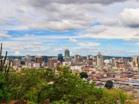A panoramic view of Lusaka city with modern buildings and busy streets under a blue sky