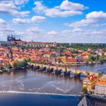 Panoramic view of Prague, featuring Prague Castle and the Vltava River at sunset