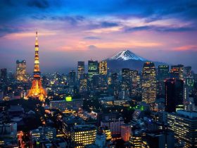 Tokyo skyline at dusk featuring Tokyo Tower and Mount Fuji in the background.