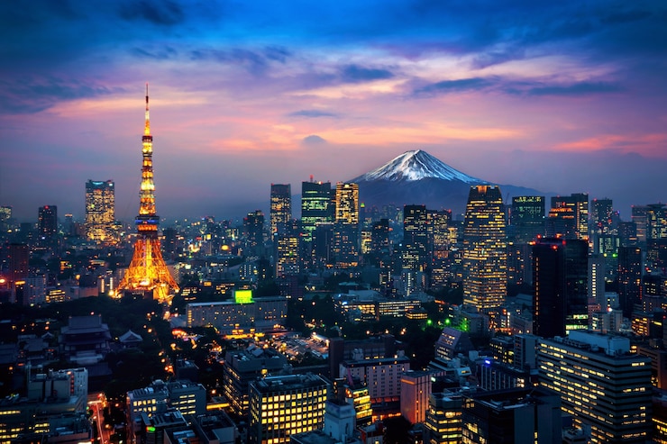 Tokyo skyline at dusk featuring Tokyo Tower and Mount Fuji in the background.